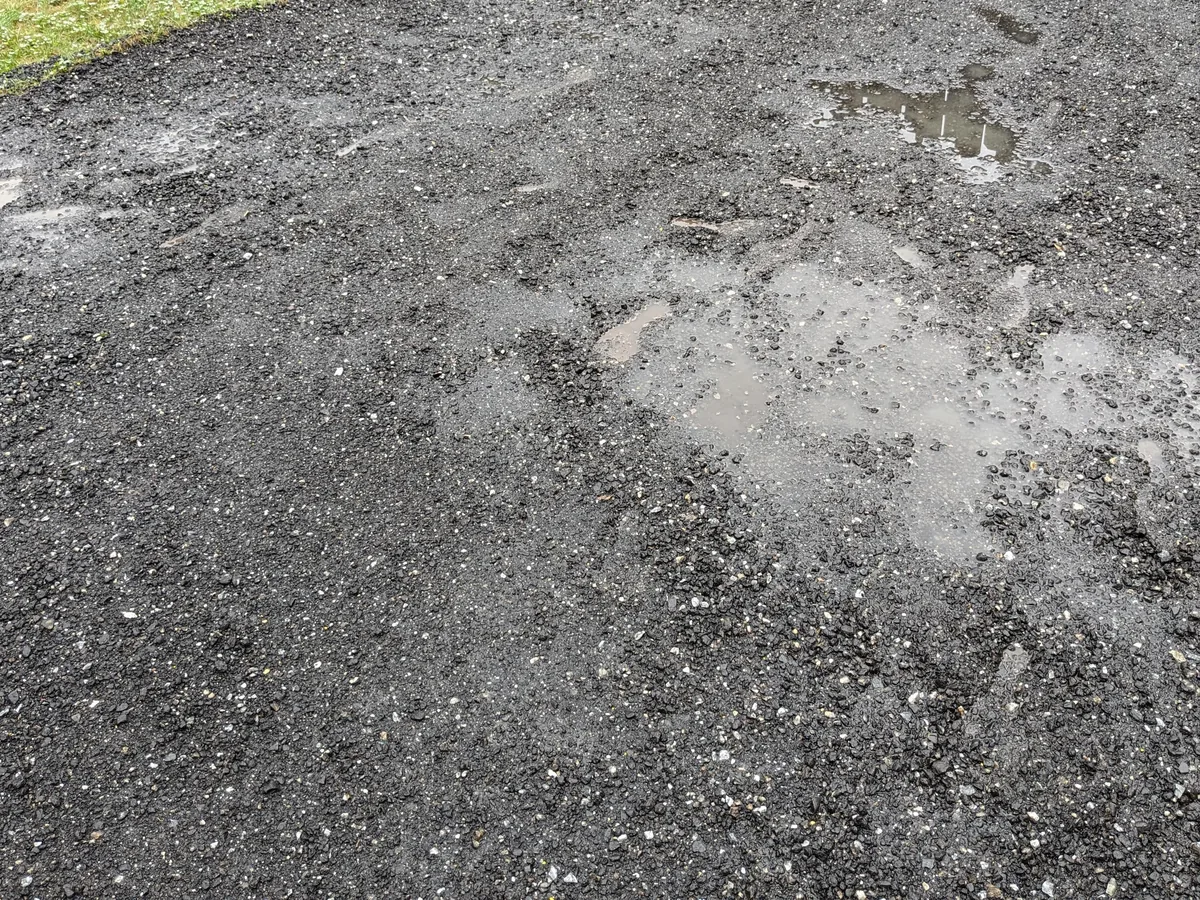 Close view of compacted asphalt millings on a driveway surface