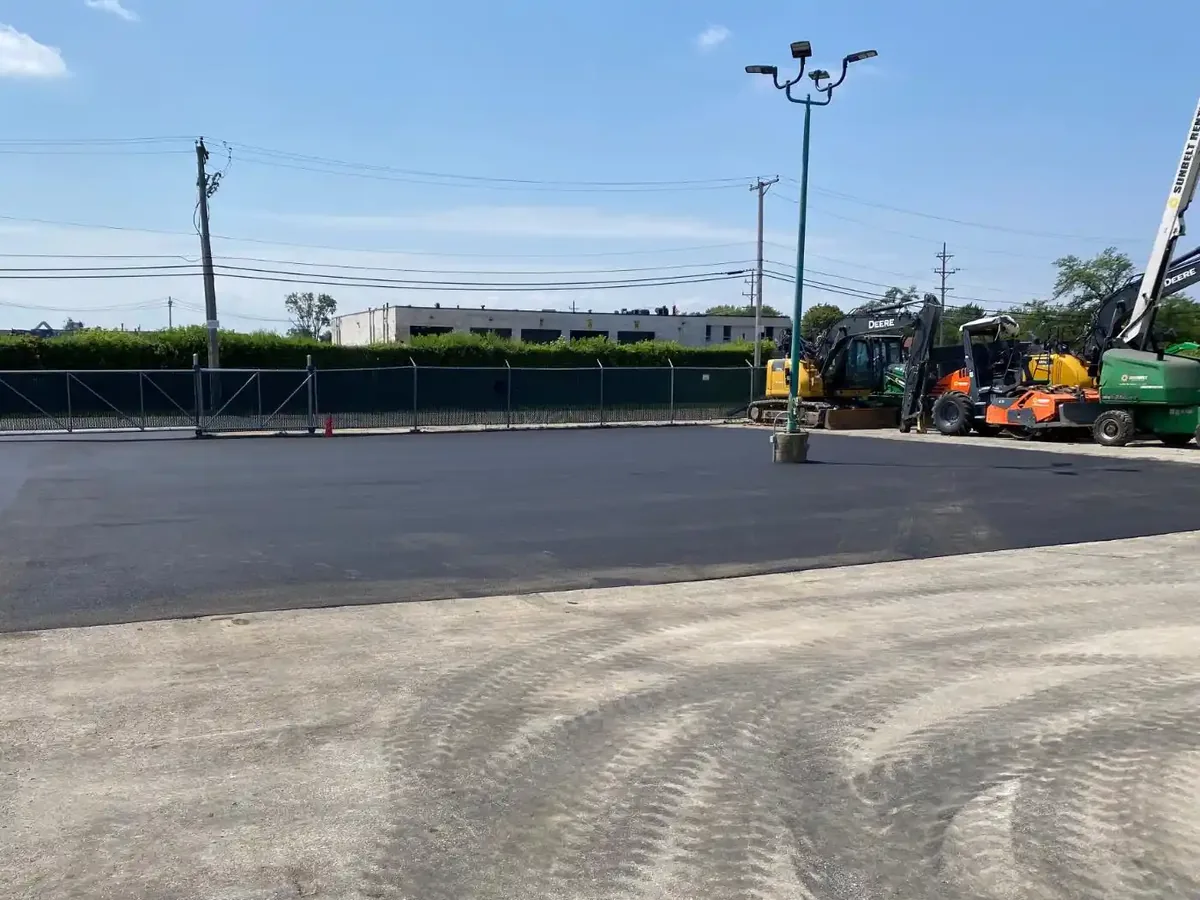 New asphalt surface meeting the older concrete section of a lot