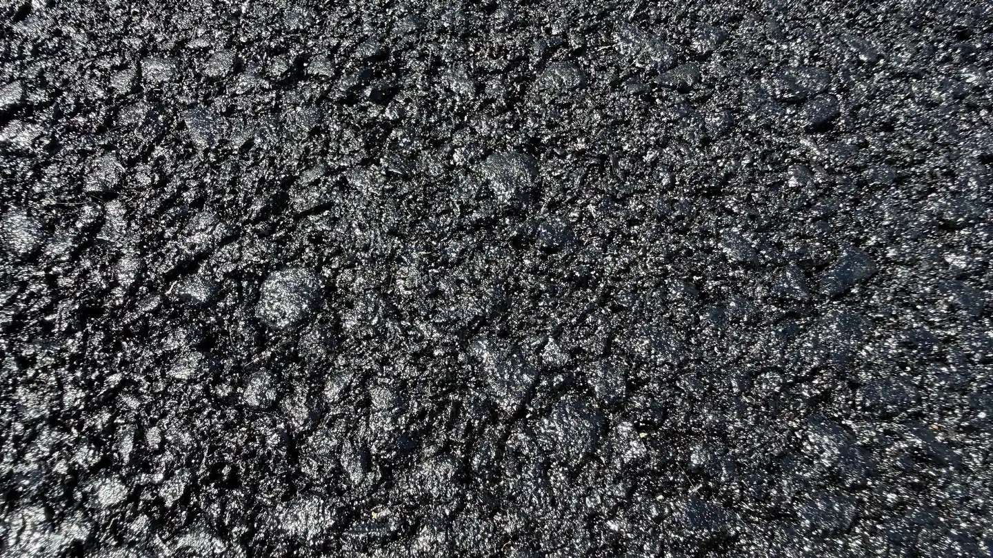Close-up of fresh hot mix asphalt on a newly paved driveway