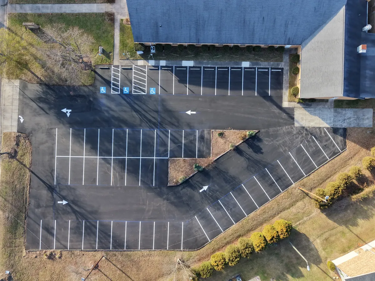 Overhead view of a freshly paved and striped parking lot with accessible spaces