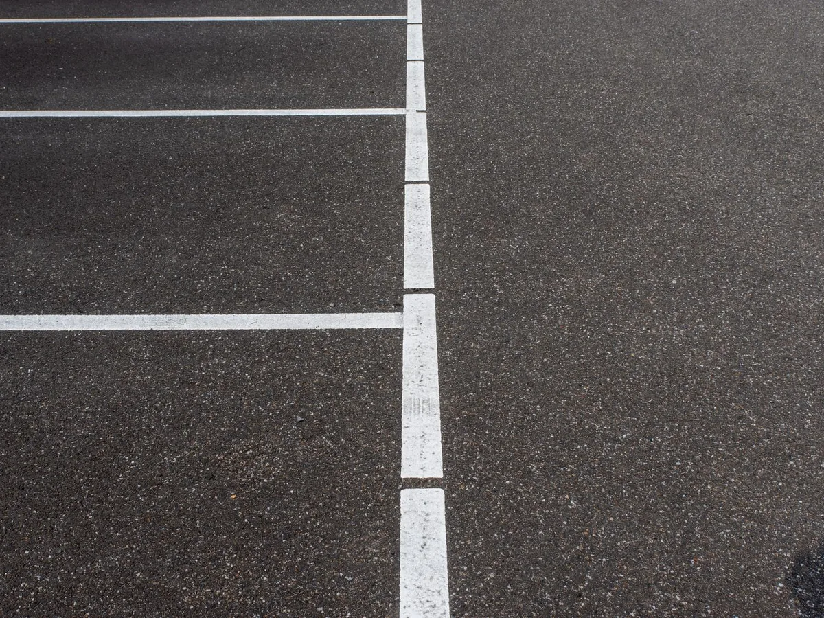 Crisp new white stall lines painted on black asphalt
